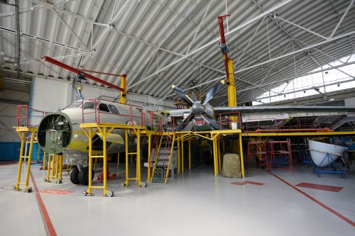 plane in a maintenance hangar surrounded by safety scaffolding